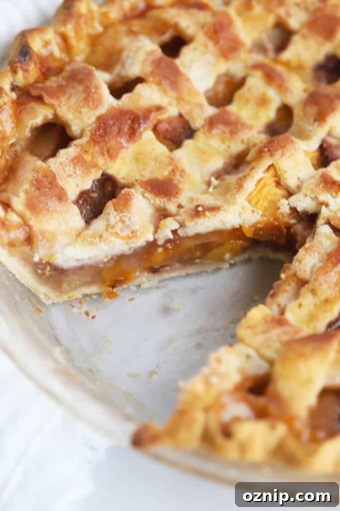 Baked Peach Pie with a Flaky Golden Crust 3 This easy baked peach pie recipe in a pie plate with a slice removed.