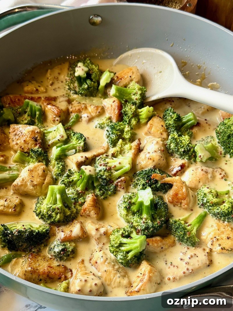 Creamy Honey Mustard Chicken with Broccoli 2 honey mustard chicken and broccoli in a skillet with a serving spoon.