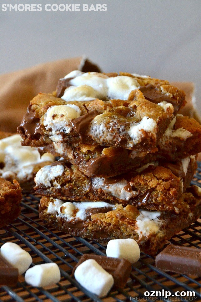 small stack of s'mores cookie bars on wire rack with mini marshmallows and chocolate