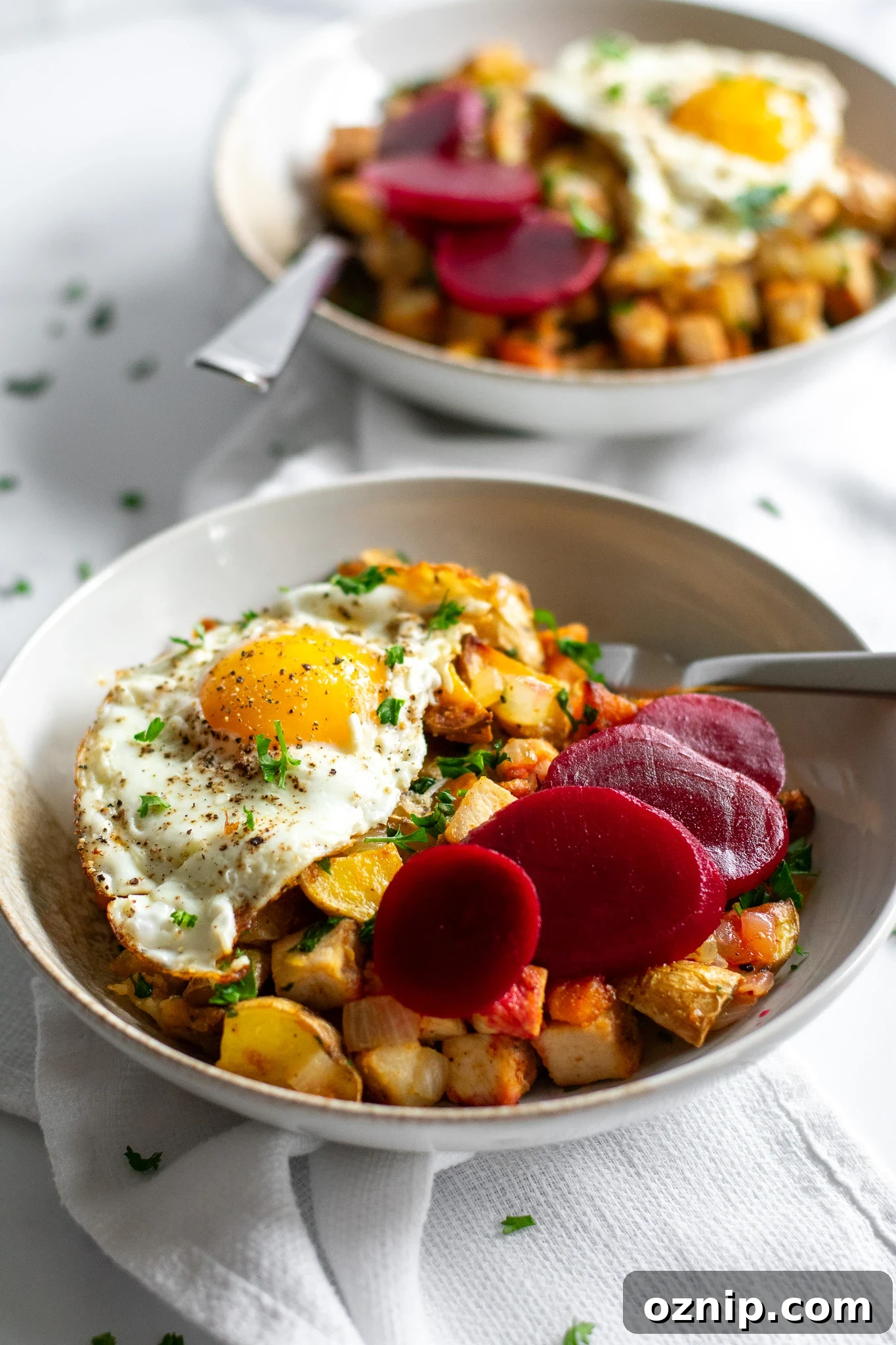 Biksemad: Traditional Danish Meat and Potato Hash Recipe 5 A bowl of veggies and meat topped with a fried egg and pickled beets.