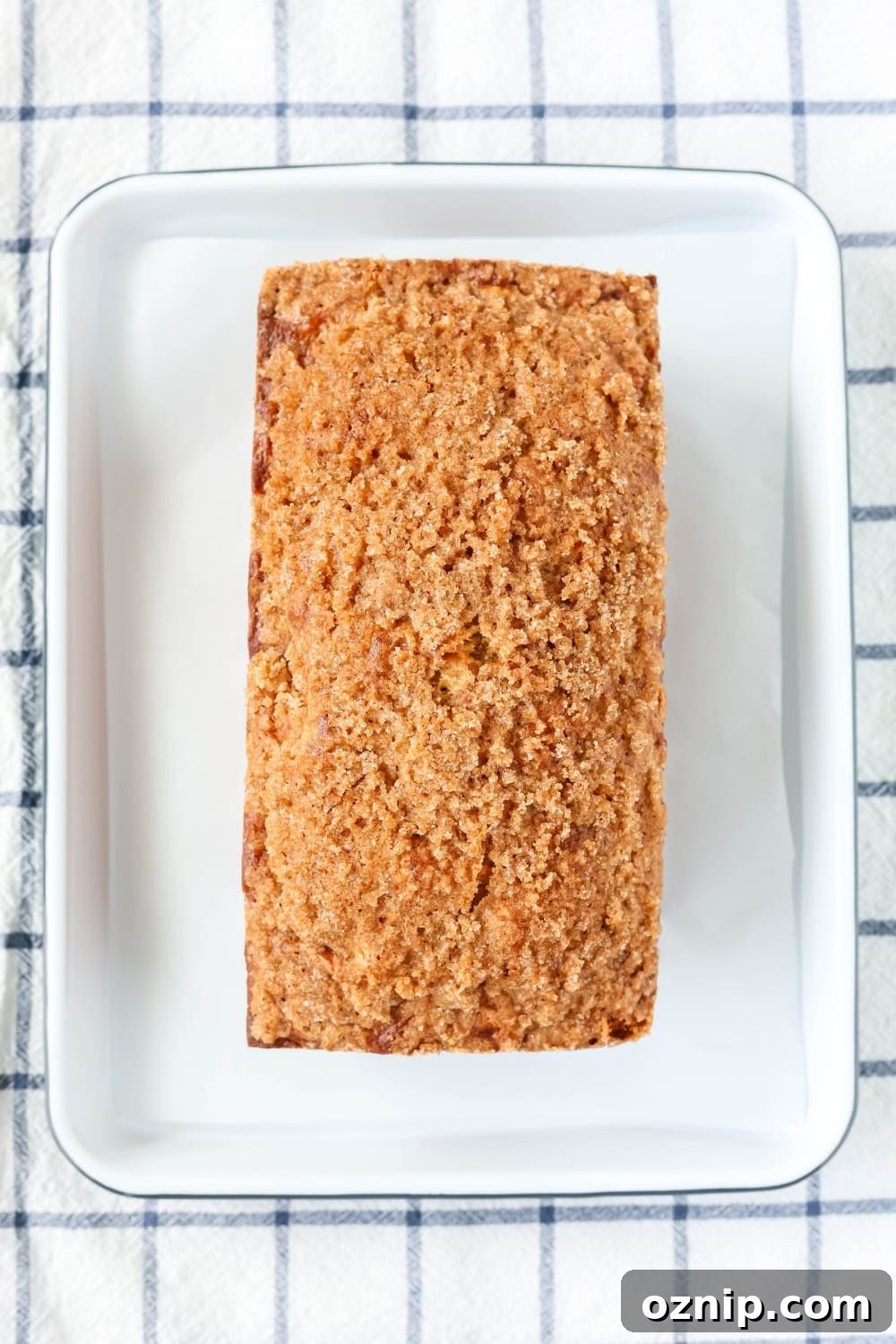overhead view of a loaf of streusel-topped pineapple bread on a white serving platter.