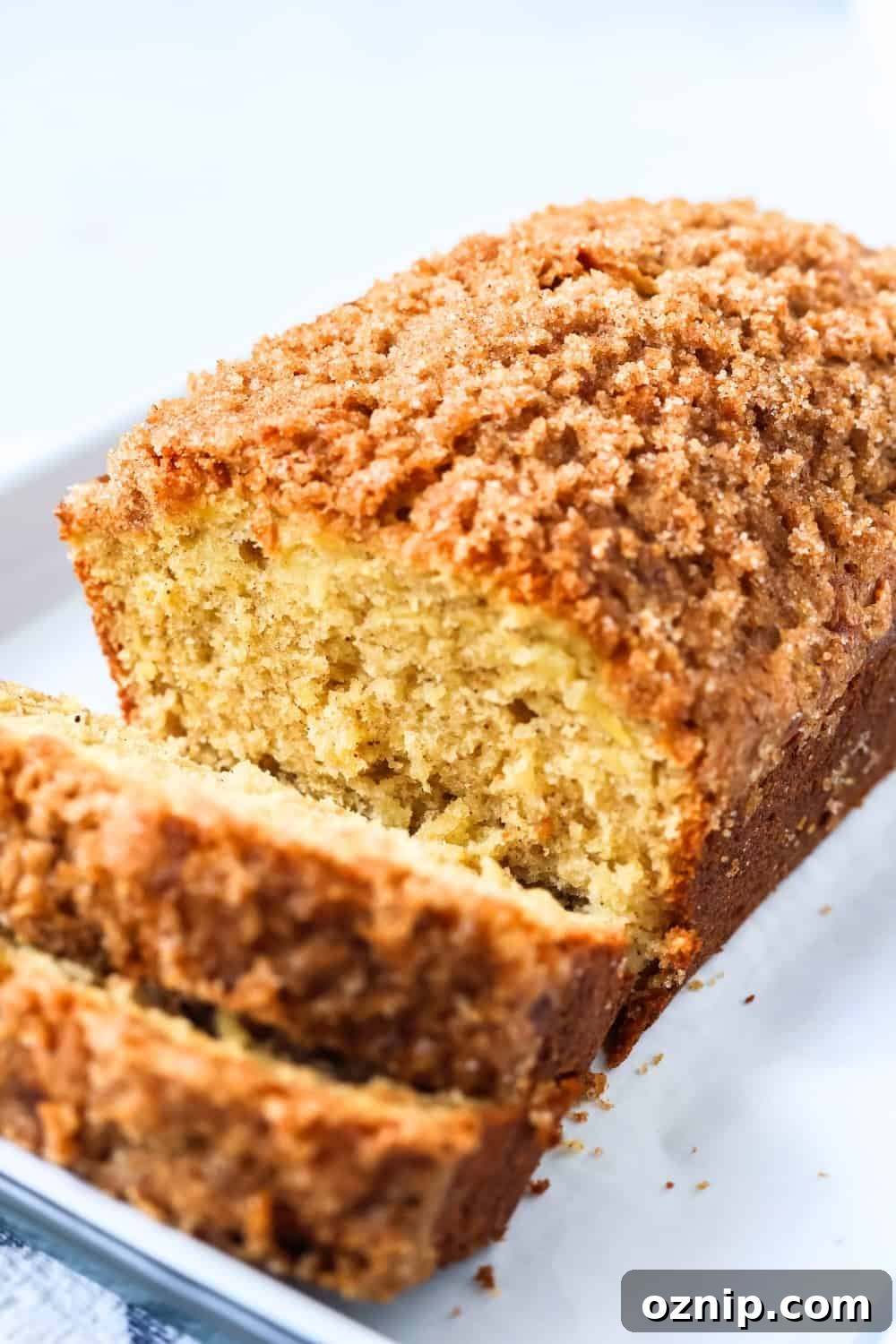 angled view of a loaf of pineapple bread made with canned pineapple. A couple of slices have been cut from the loaf.