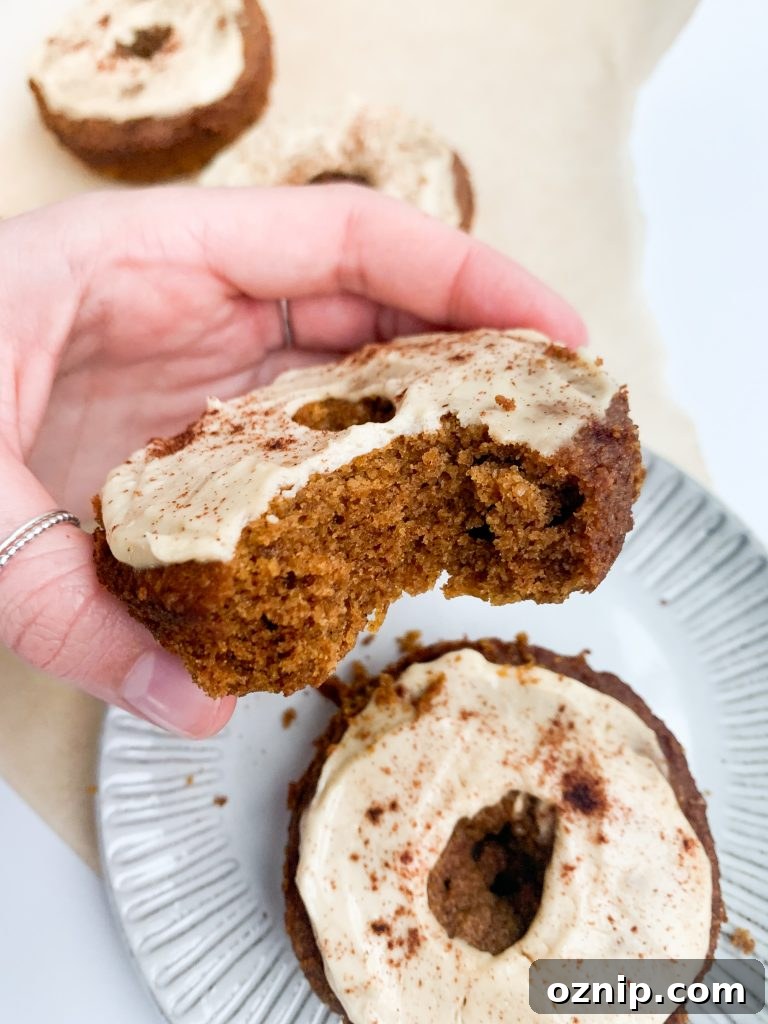 Fluffy Pumpkin Donuts with Cream Cheese Frosting 4 Pumpkin donuts on a cooling rack