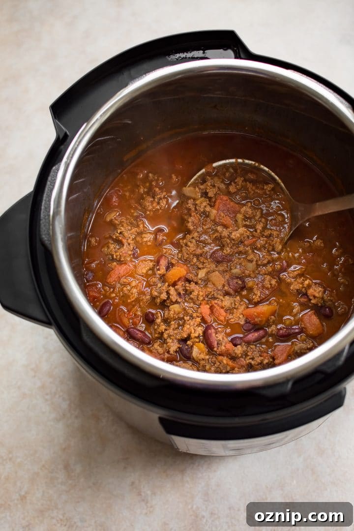 Instant Pot electric cooker with beef chili and a ladle