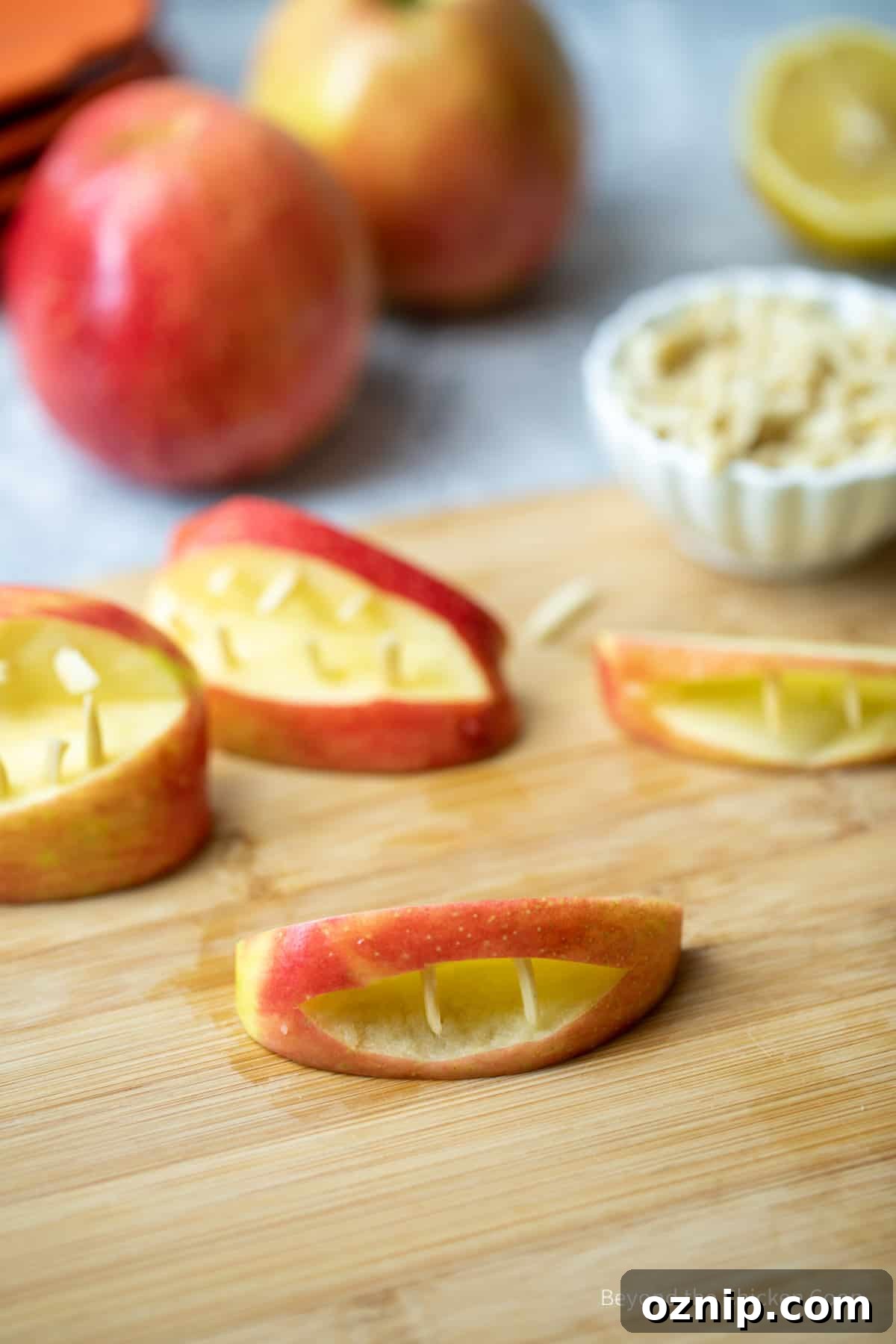 How to Make Apple Teeth for Halloween 5 A sliced apple filled with slivered almonds making a mouth shape.
