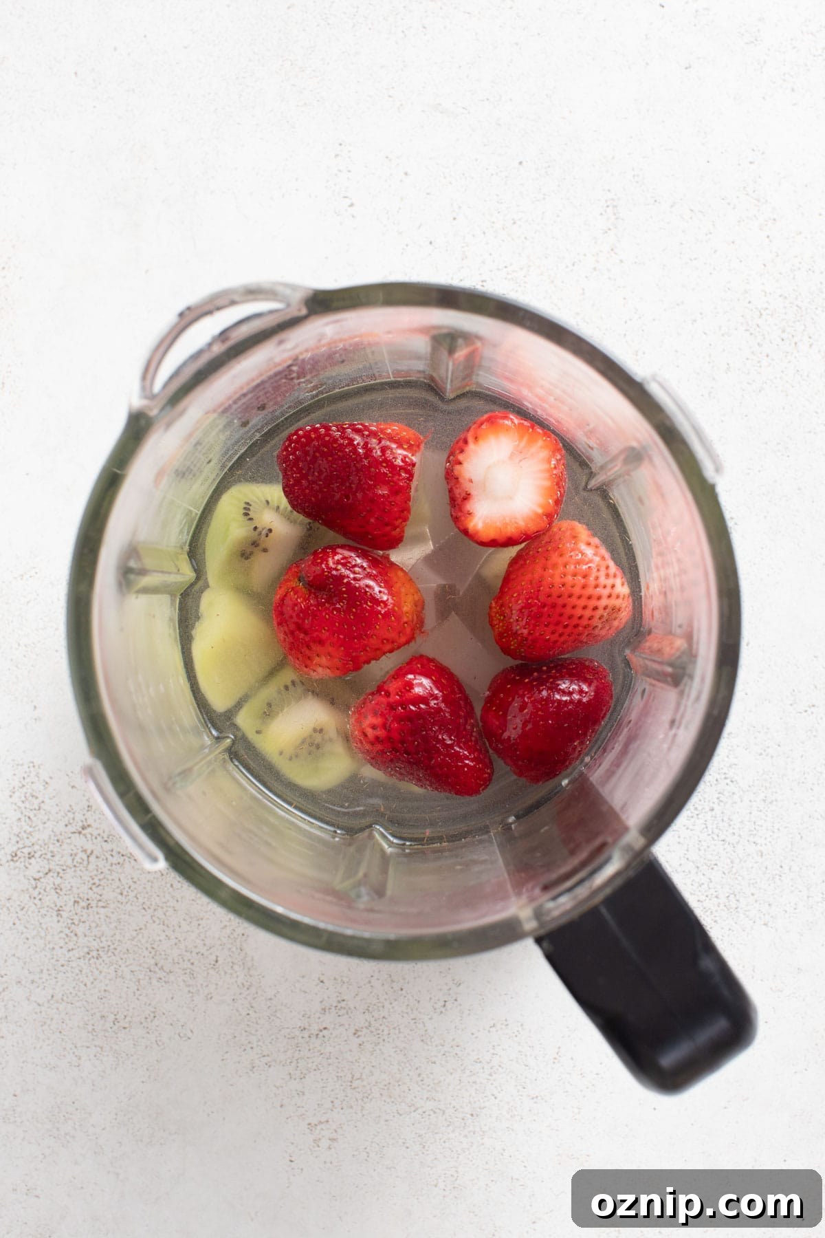 Strawberry Cocktail to Reduce Cortisol, No Orange Juice 4 A blender with kiwi and strawberries, and coconut water.