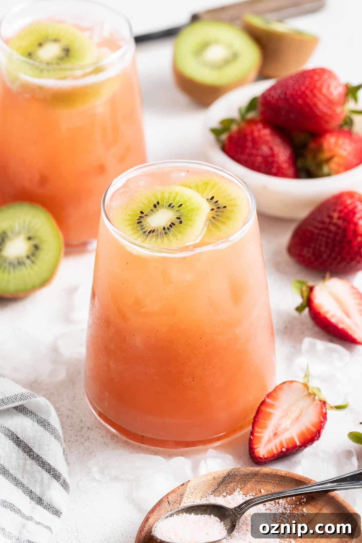 Strawberry Cocktail to Reduce Cortisol, No Orange Juice 9 A strawberry cortisol mocktail on a table with kiwi and sliced strawberries.