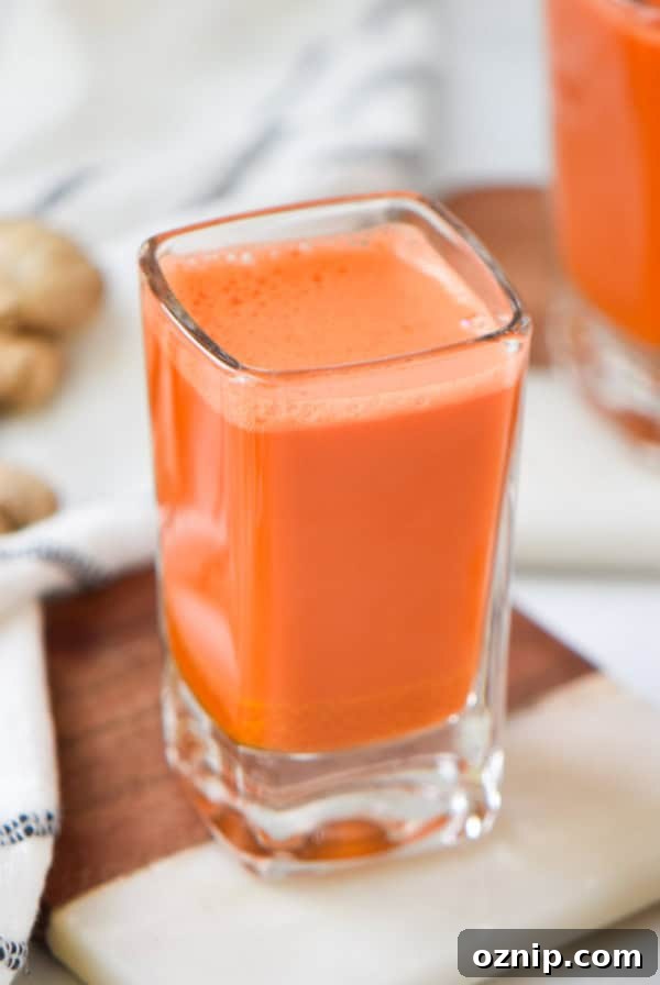 Strawberry Cocktail to Reduce Cortisol, No Orange Juice 10 Two carrot wellness shots next to fresh ginger root.
