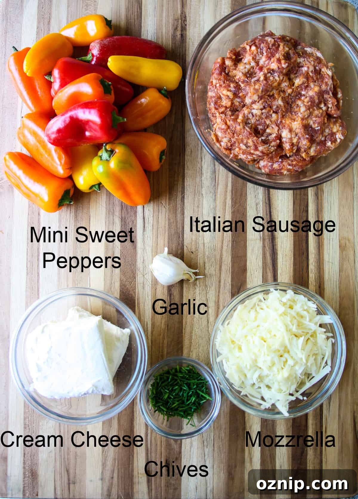 Sausage Stuffed Mini Peppers Recipe 4 The recipe ingredients in glass dishes on a wooden board.