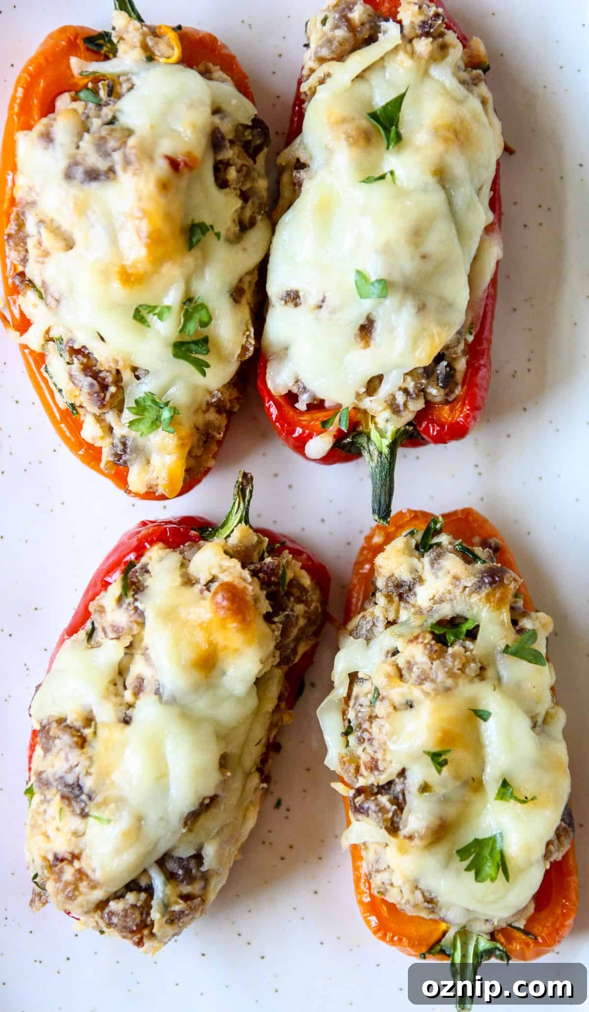 Sausage Stuffed Mini Peppers Recipe 8 Sausage stuffed mini peppers served on a white plate.