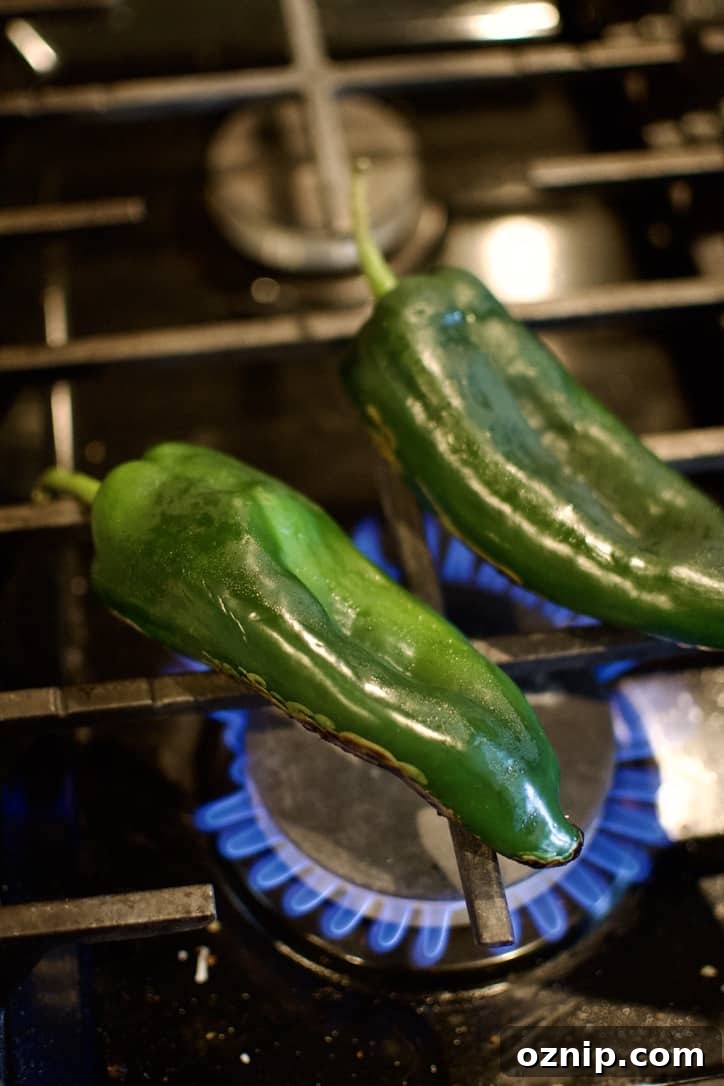 Blistering poblano peppers over a gas stove.