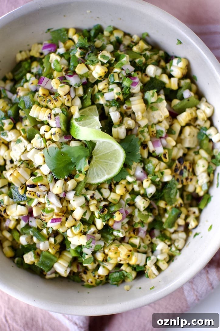 Roasted Chili-Corn Salsa ready to eat garnished with a lime slice and cilantro.