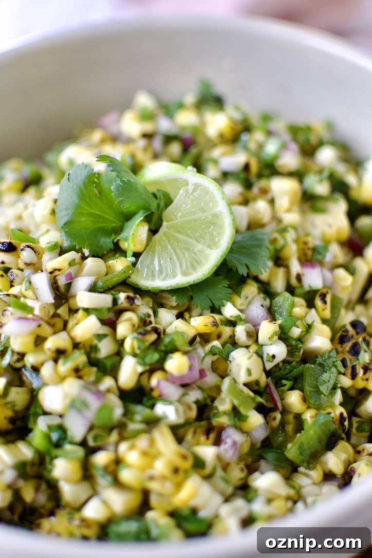 Roasted Chili-Corn Salsa ready to eat garnished with a lime slice and cilantro.