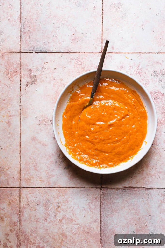 Moist Baked Pumpkin Donuts: Soft Fall Donut Recipe 4 A bowl with eggs and pumpkin mixture with a fork.