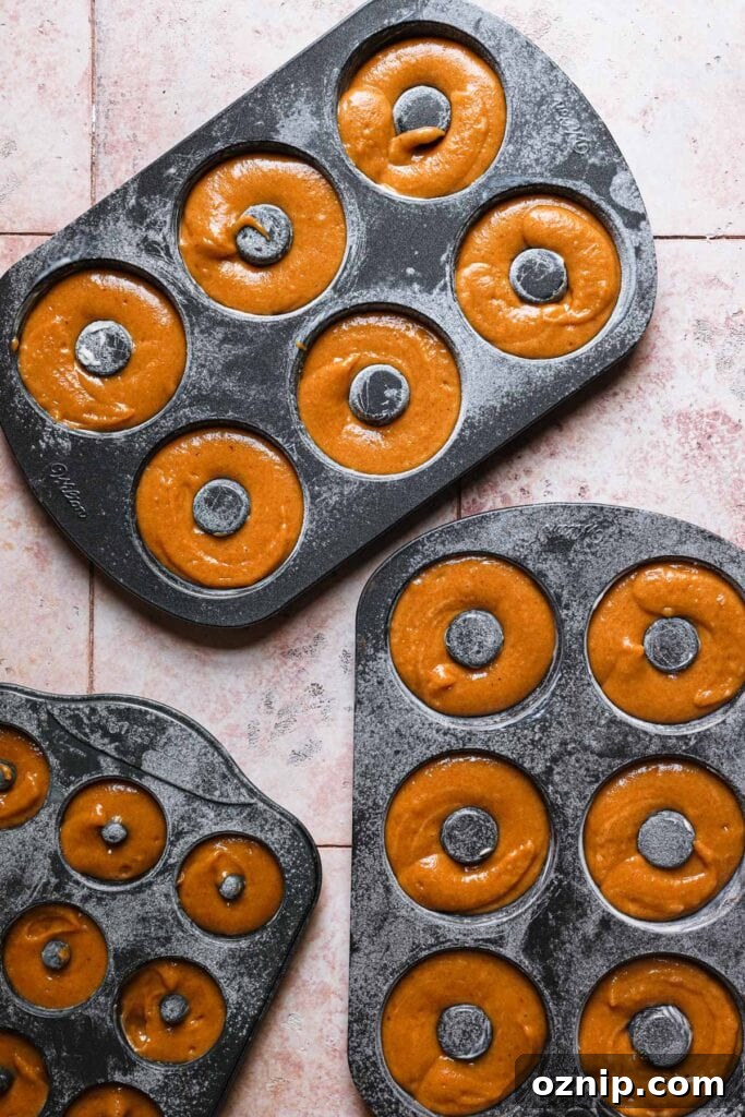 Moist Baked Pumpkin Donuts: Soft Fall Donut Recipe 7 Donut mold filled with pumpkin batter.