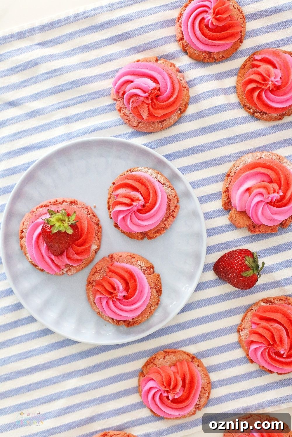 Image of strawberry and cream cookies decorated with fresh strawberries, on a kitchen napkin