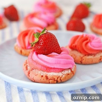 Image of strawberry cream cookies decorated with cream cheese frosting and fresh strawberries, on a serving plate