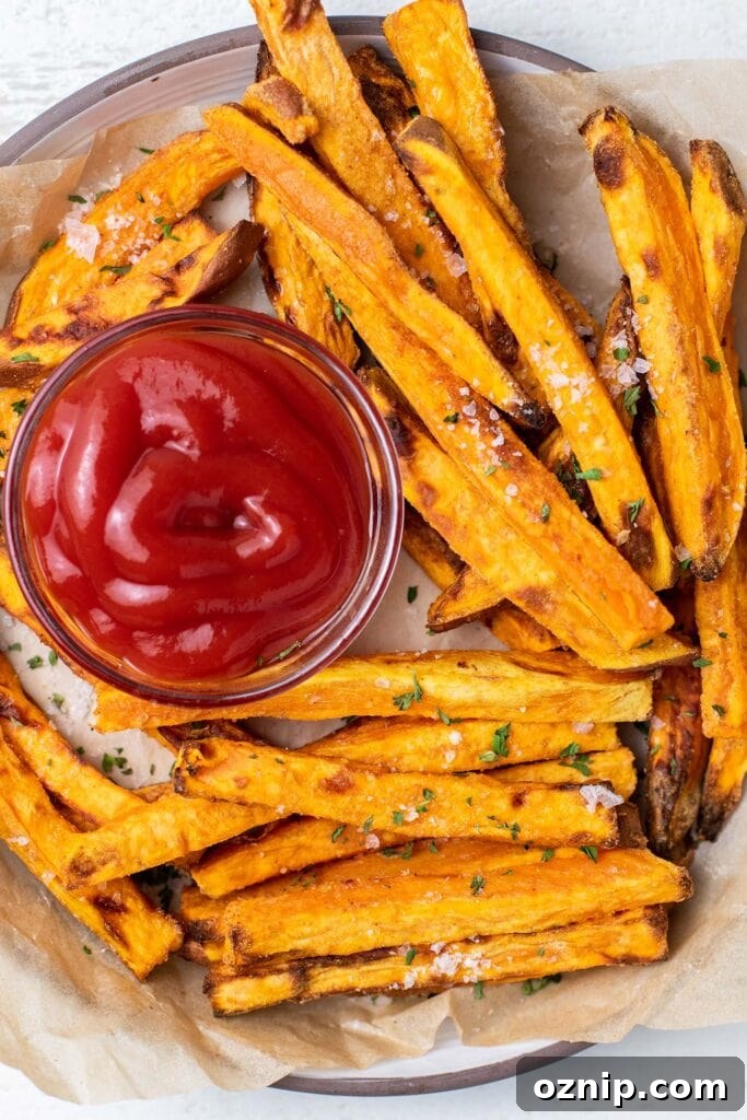 A plate with crispy air fryer sweet potato fries served with ketchup.