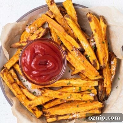 A plate with air fryer sweet potato fries and a little dish of ketchup.