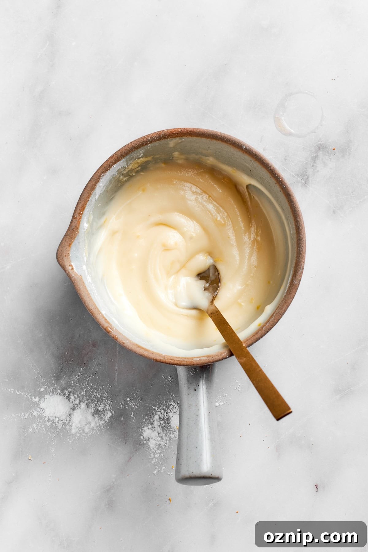 A spoon stirs lemon slice icing.