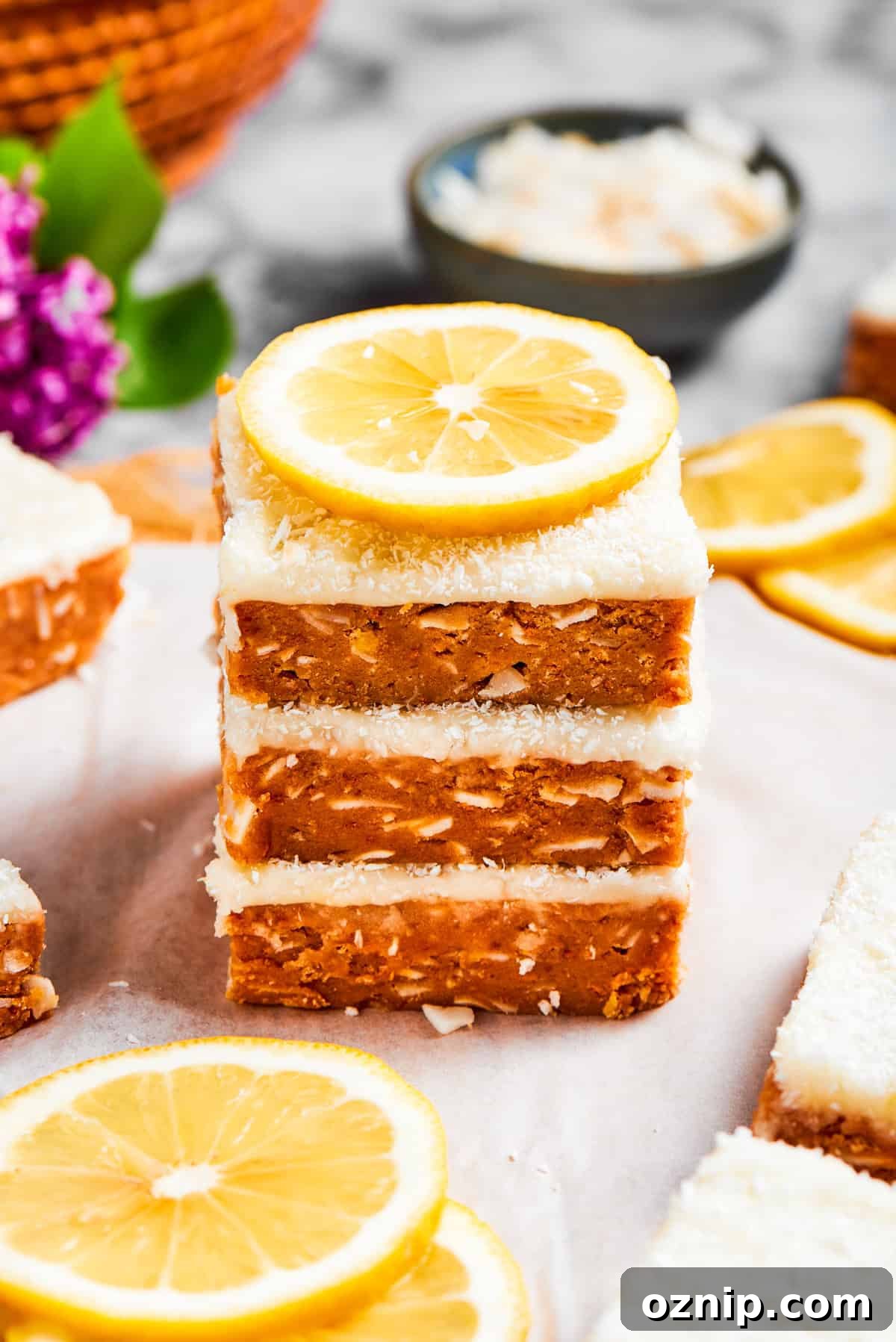 A stack of lemon slice squares garnished with lemon.
