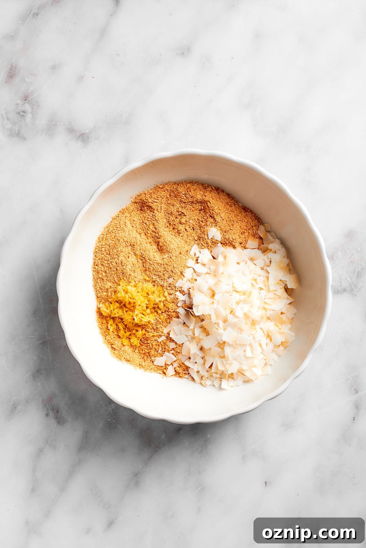 Coconut flakes added to crushed graham crackers.