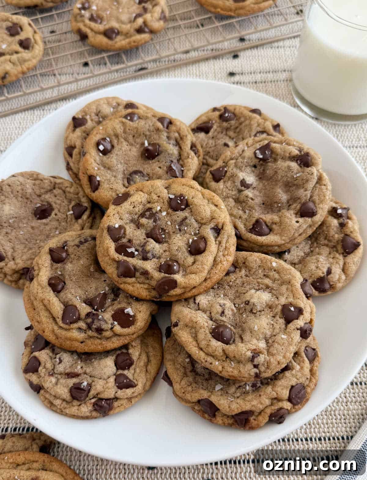chocolate chip cookies with flaky salt on a plate with milk.