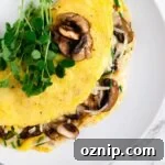 Mushroom Omelette Recipe with Cheese and Herbs 8 A top down view of a mushroom omelette topped with microgreens.