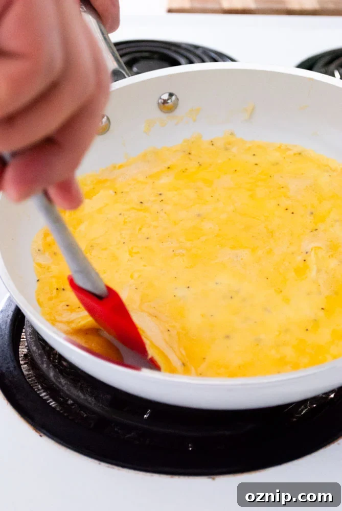 Mushroom Omelette Recipe with Cheese and Herbs 5 Lifting the edge of an omelette with a spatula.