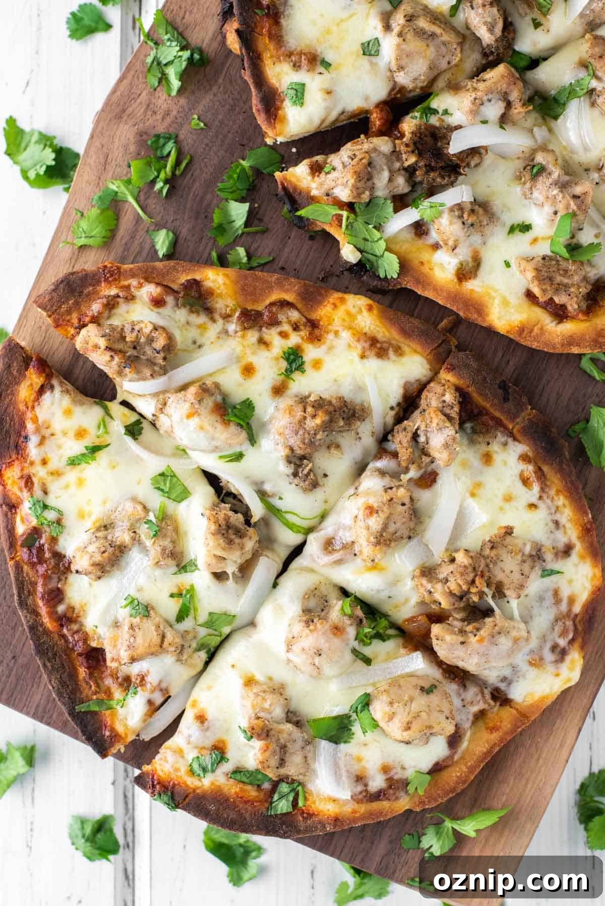 overhead shot of chicken tikka pizza on wood board