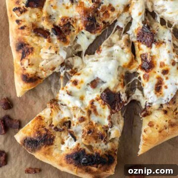Slice of chicken and bacon pizza being pulled away.