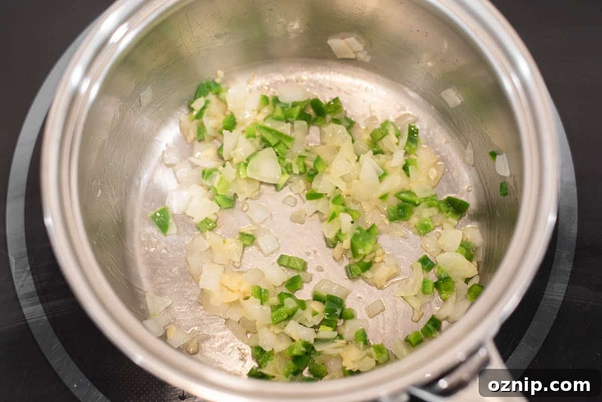 Onions, garlic and peppers cooking in pot.