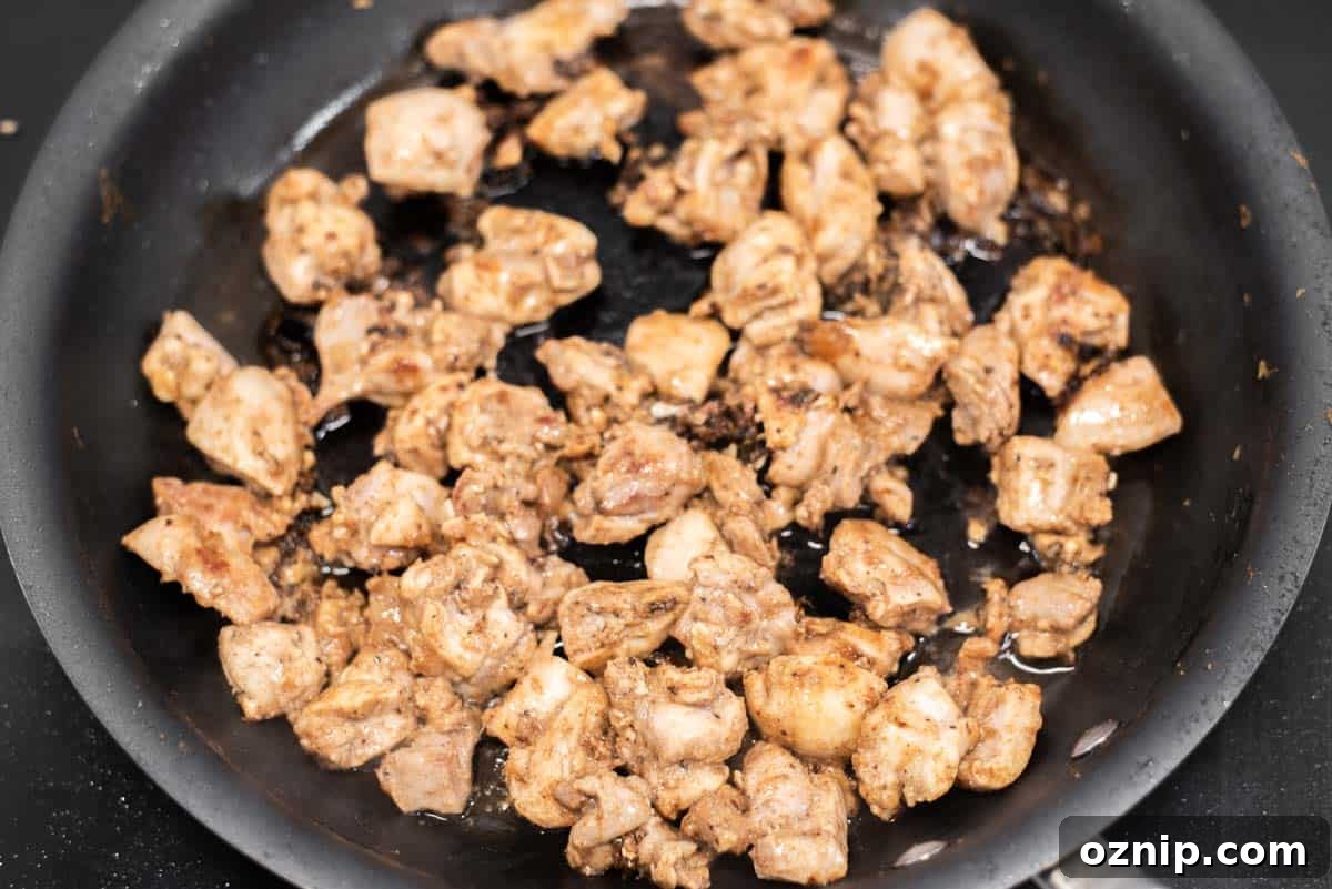 Chicken cooking in skillet.