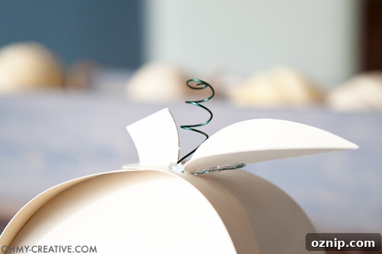 Make these easy paper pumpkins for your Thanksgiving table or any DIY Thanksgiving decorations. You can fill them with treats, use them as a place card, or just put them on your mantle to decorate. | OHMY-CREATIVE.COM