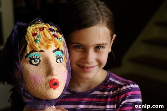Styrofoam Head Self Portrait Art Project for Kids 14 Girl holding decorated styrofoam head