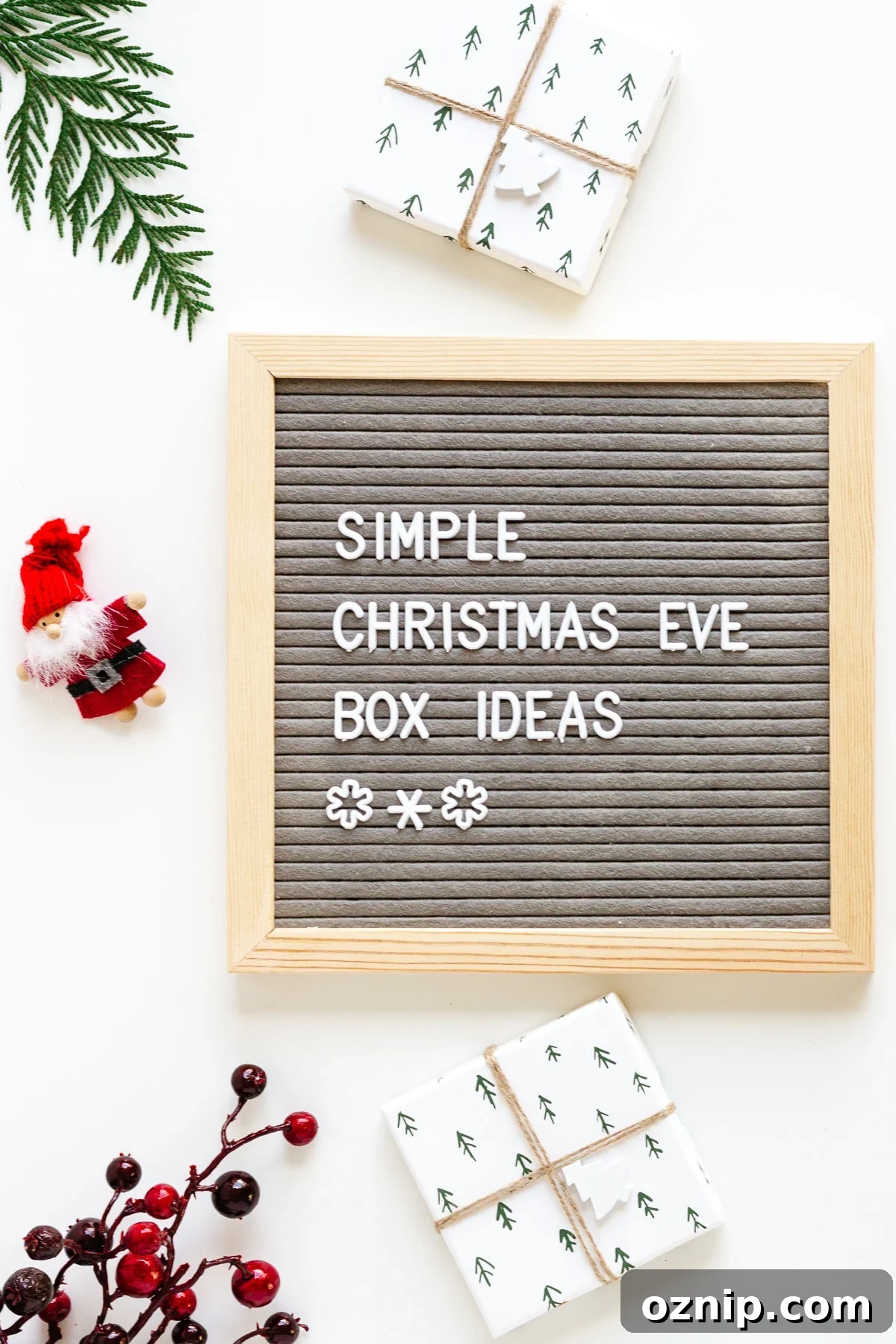 Flatlay photo of a letterboard that says 'Simple Christmas Eve Box Ideas' surrounded by some gifts and christmas decor items.
