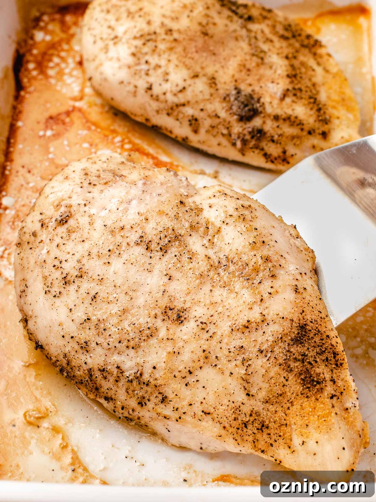 Baked chicken breast in a baking dish.