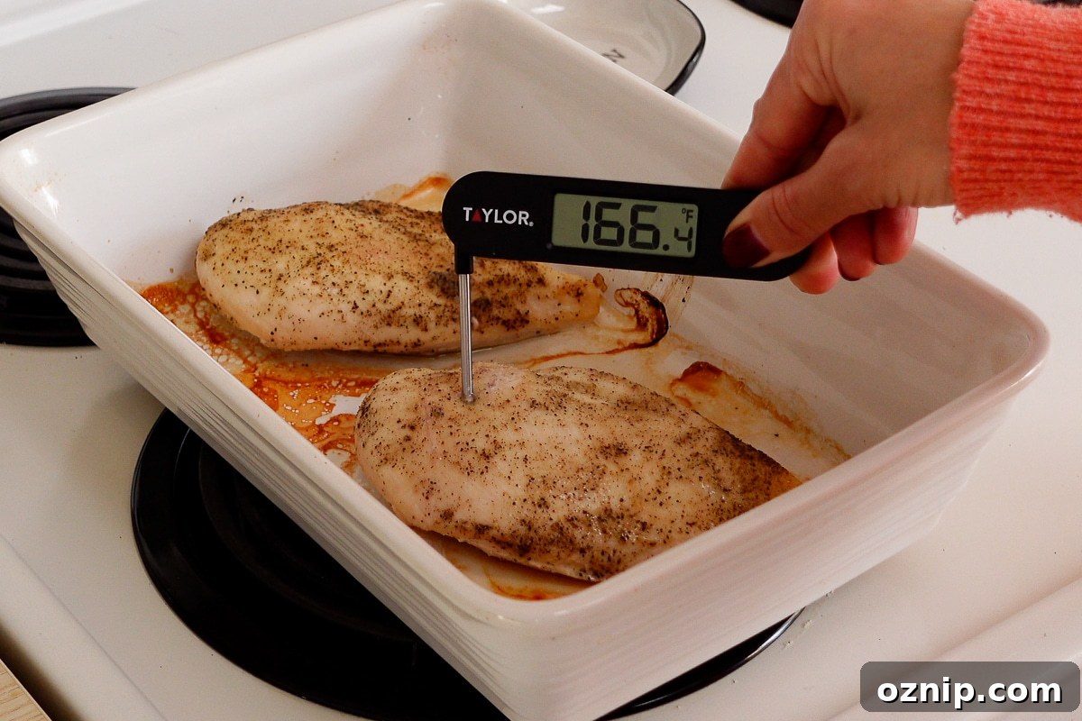 A woman checking the internal temperature of a chicken breast.