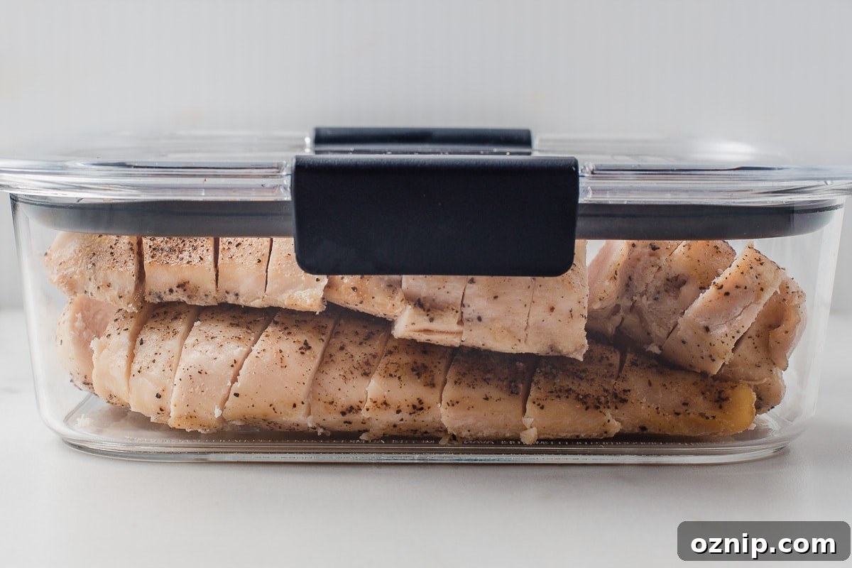 Baked chicken breast in a meal prep container.