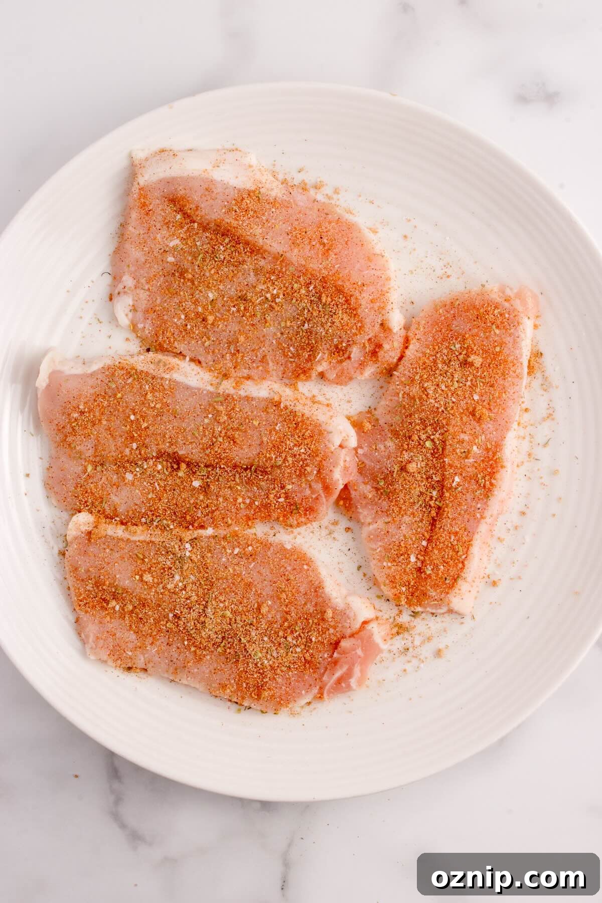 Thinly sliced seasoned pork chops on a plate.