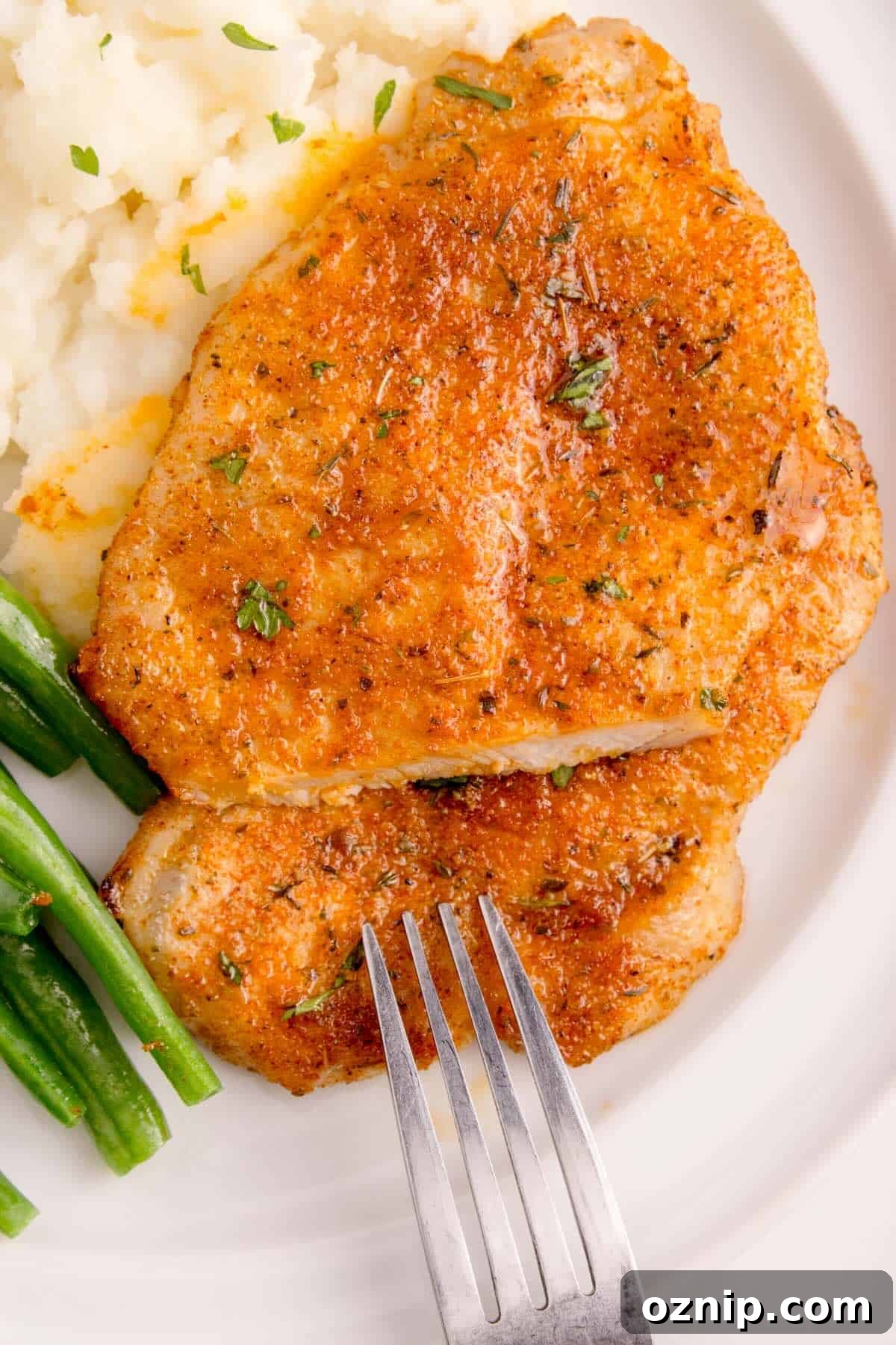 Juicy pork chops, resting on a plate.