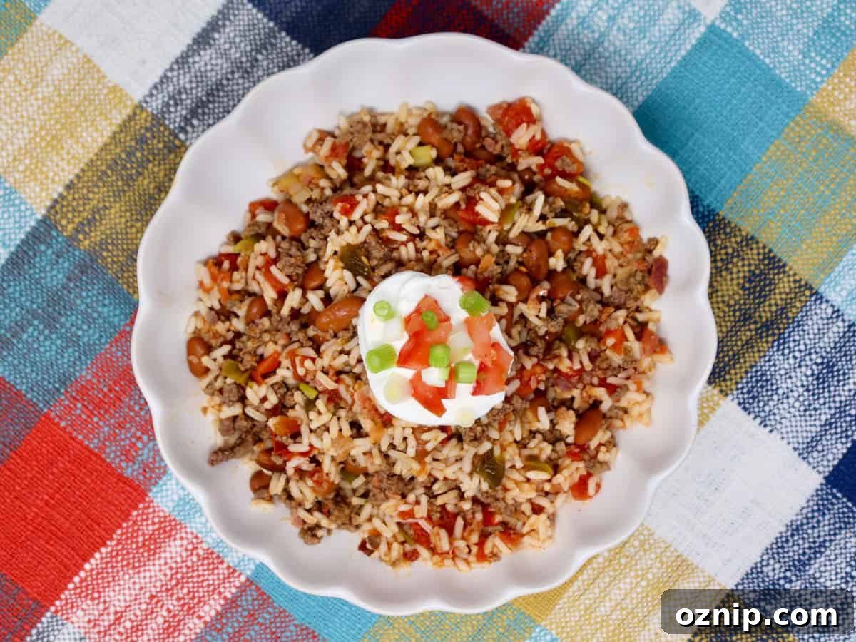 Honey Sesame Popcorn Chicken: Air Fryer or Oven Recipe 10 Ground beef rice and beans served in a white bowl with sour cream and green onions on top