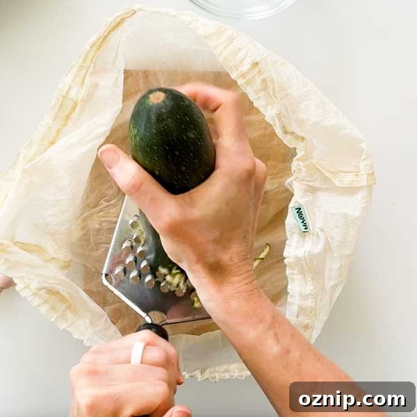 Shredding a zucchini into a strainer bag.