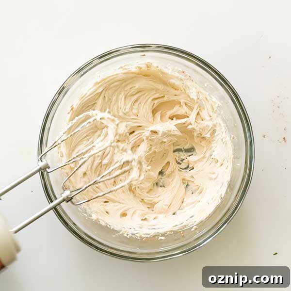 Creaming together the cream cheese and butter and a mixing bowl.