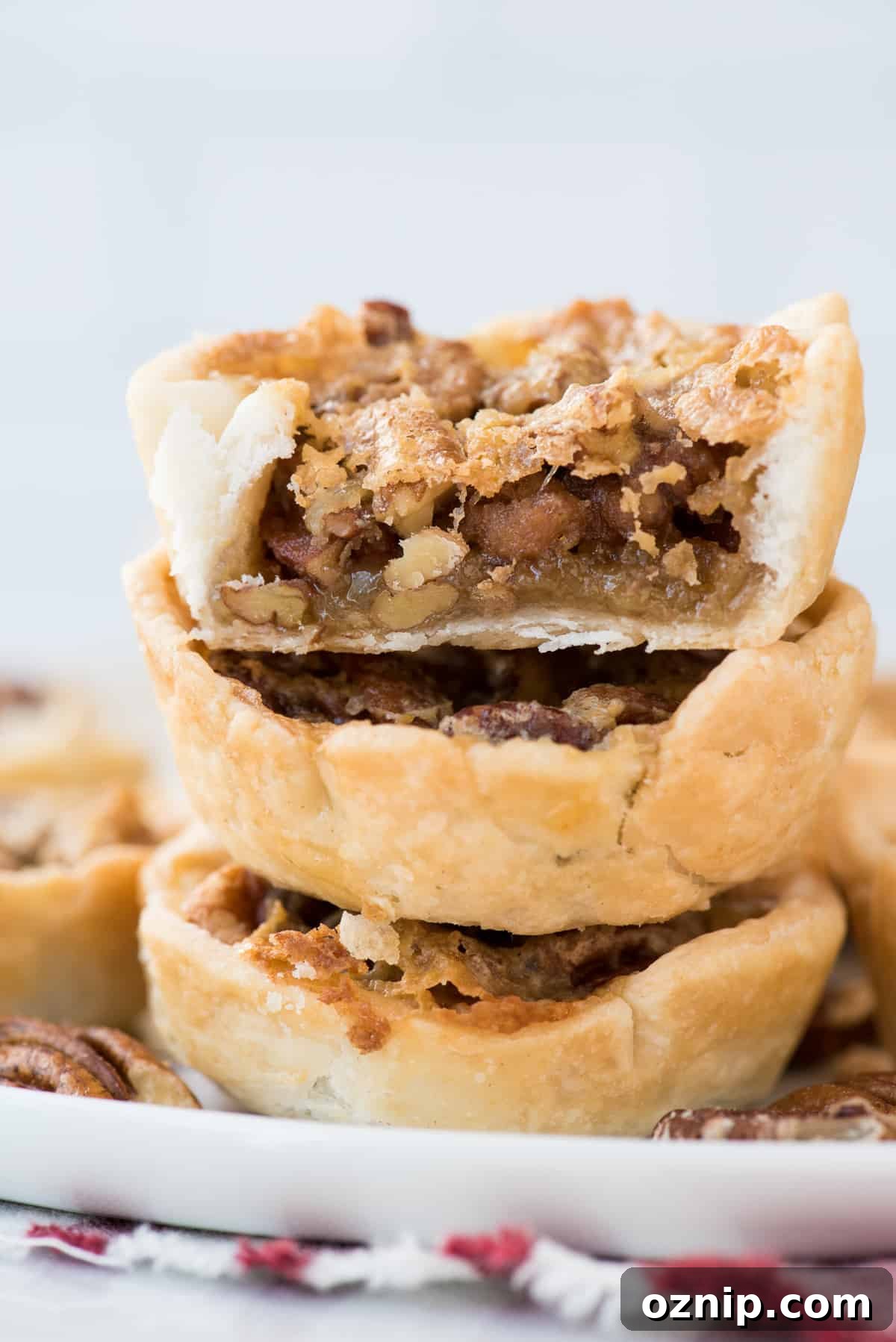 three mini pecan pies stacked on top of each other with bite removed from top pie