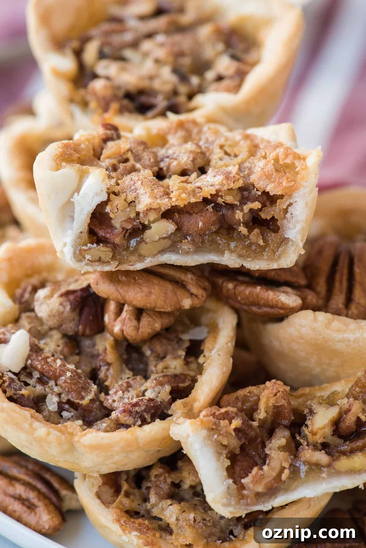 mini pecan pies in a pile with bite removed from the center pie