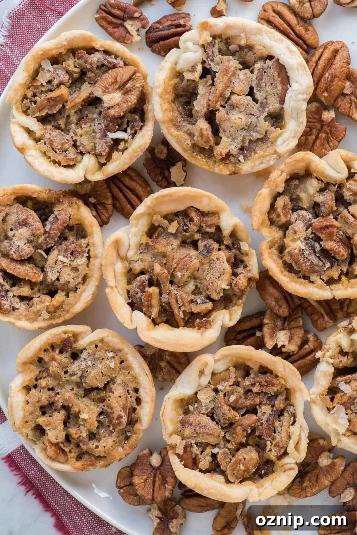 aerial shot of 8 mini pecan pies on white tray with red linen 