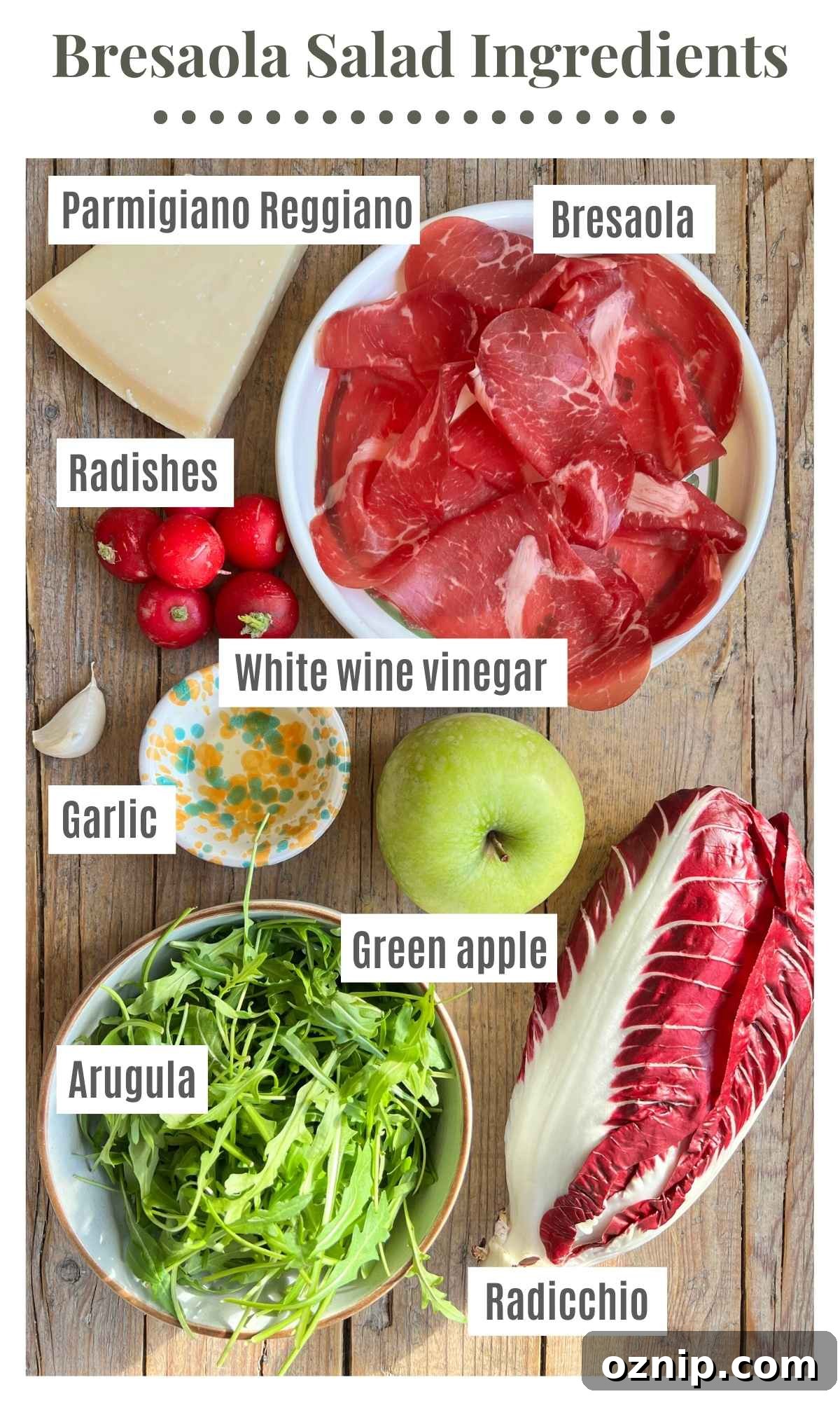 All the ingredients to make a bresaola salad on a wooden surface.