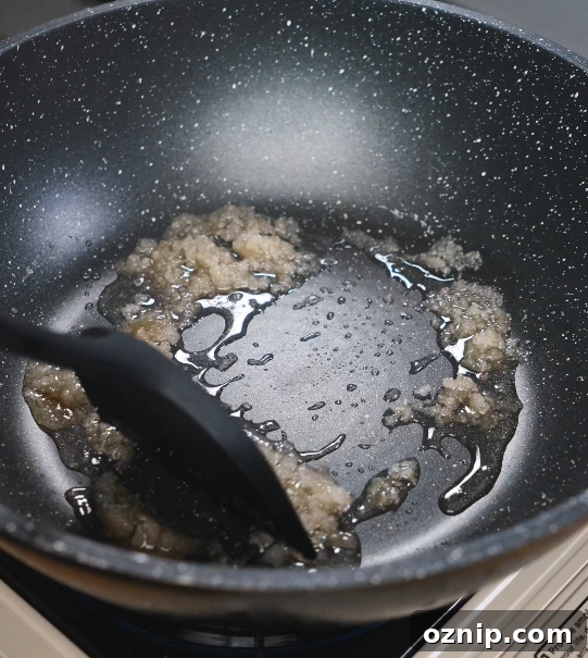 Chinese Red Braised Pork Belly Recipe 5 Sugar slowly melting and caramelizing in oil in a pan, creating the deep amber base that gives red braised pork belly its signature color and sweetness.