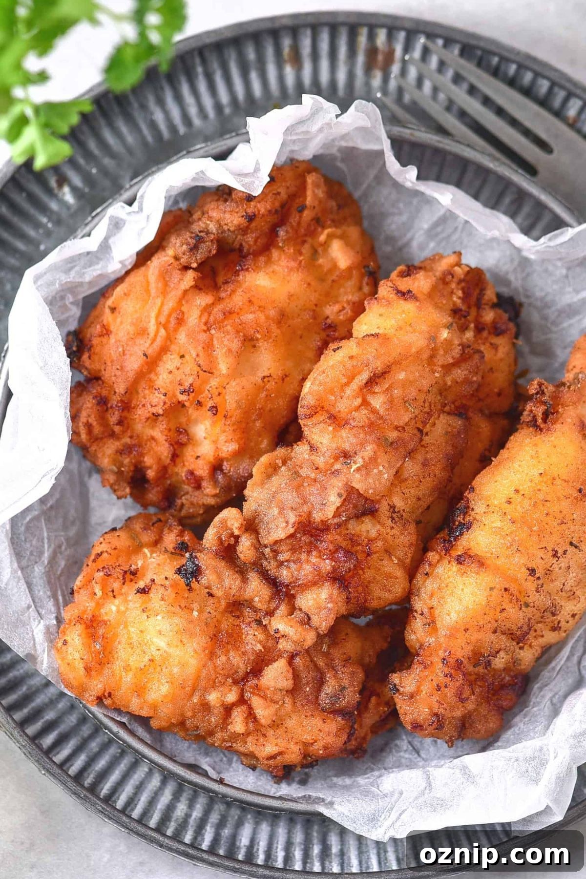 Gluten-Free Fried Chicken Recipe (Dairy-Free) A plate of gluten-free fried chicken on parchment paper.
